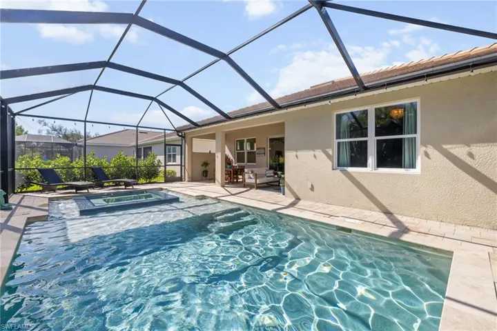 View of swimming pool with a sunroom, a patio area, a lanai, and a pool with connected hot tub
