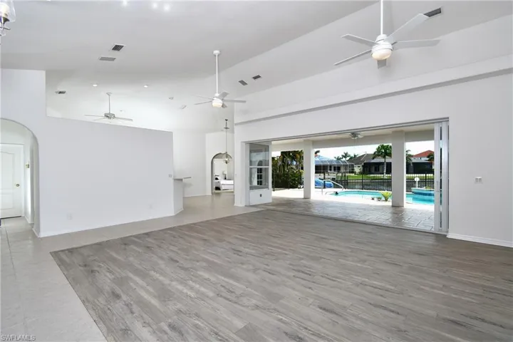 Unfurnished living room with high vaulted ceiling and wood-type flooring