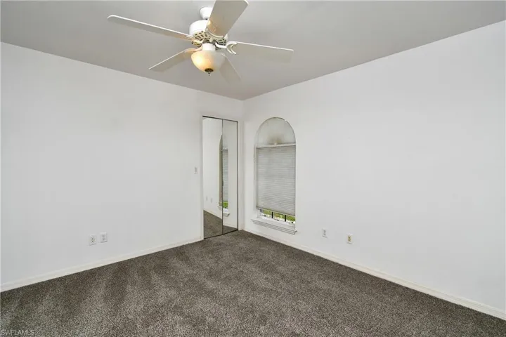 Unfurnished room featuring carpet flooring and ceiling fan