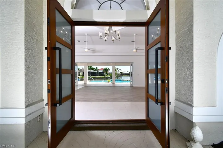 Entryway featuring ceiling fan with notable chandelier and light hardwood / wood-style flooring