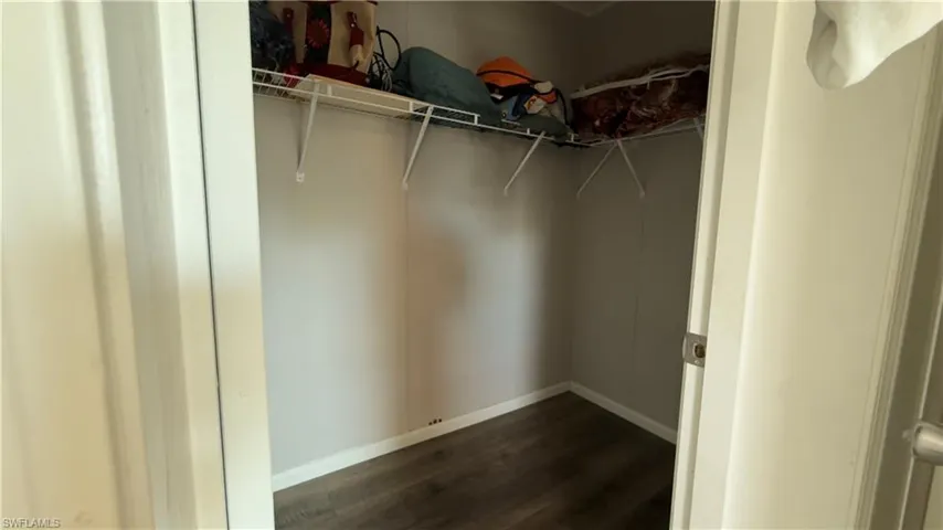 Walk in closet featuring dark wood-type flooring