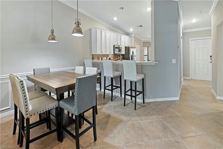 Dining room featuring crown molding and lofted ceiling