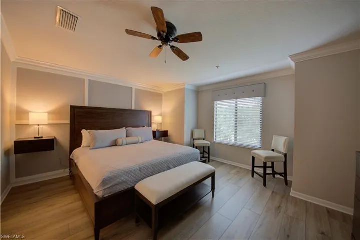 Bedroom featuring ceiling fan, ornamental molding, and light hardwood / wood-style flooring