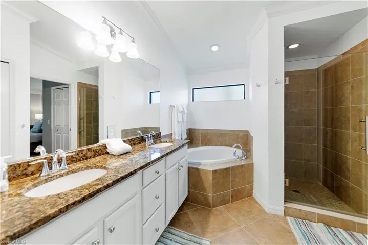 Bathroom featuring tile patterned floors, vanity, separate shower and tub, and crown molding