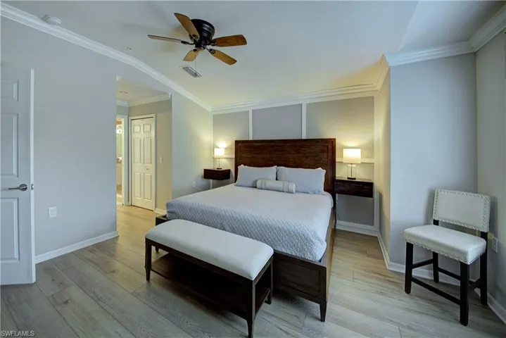 Bedroom featuring ceiling fan, light hardwood / wood-style floors, ornamental molding, and vaulted ceiling