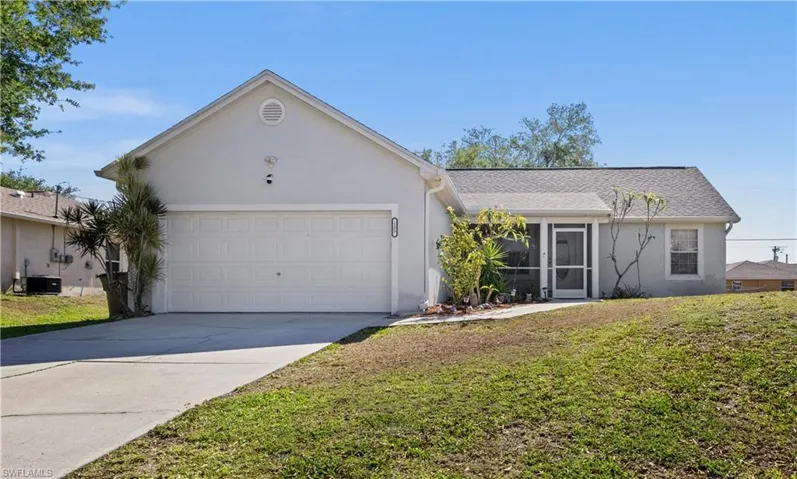 Single story home with stucco siding, a front lawn, concrete driveway, and a garage