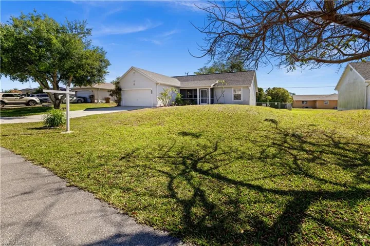 Ranch-style house with an attached garage, stucco siding, concrete driveway, and a front lawn