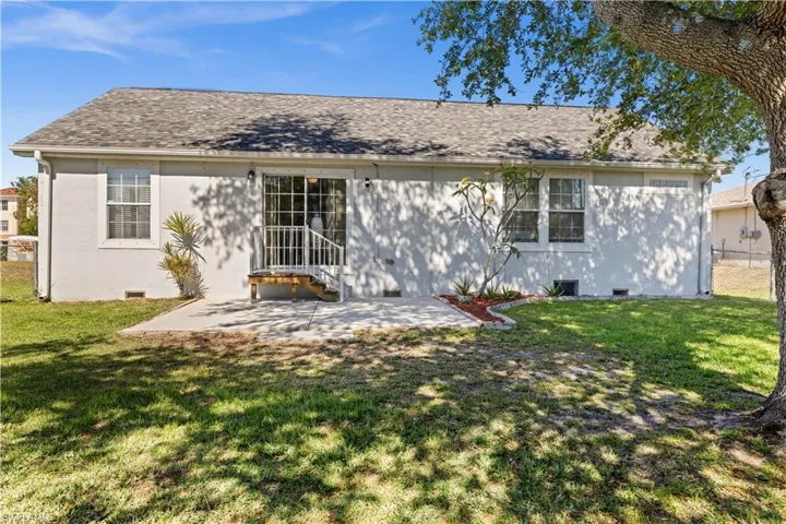 Back of property featuring a patio area and a shingled roof