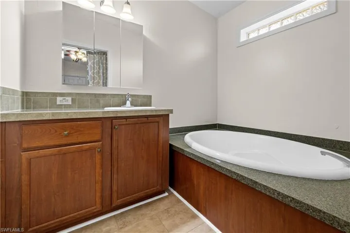 Full Master bathroom featuring vanity, a bath, and decorative backsplash
