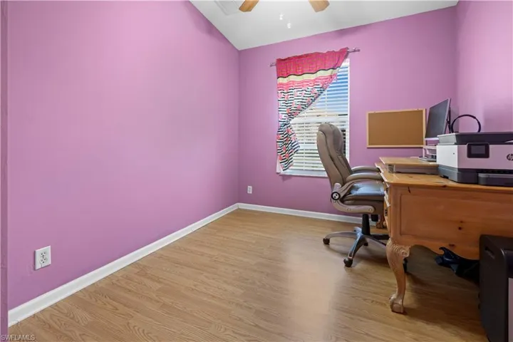 Home office/ bedroom featuring light wood-style flooring, a ceiling fan, and lofted ceiling