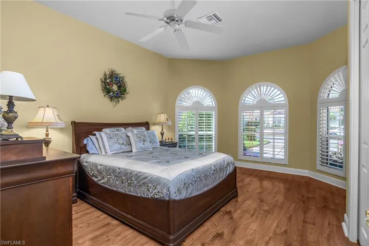 Front guest bedroom with "wagon wheel" plantation shutters and wood flooring.