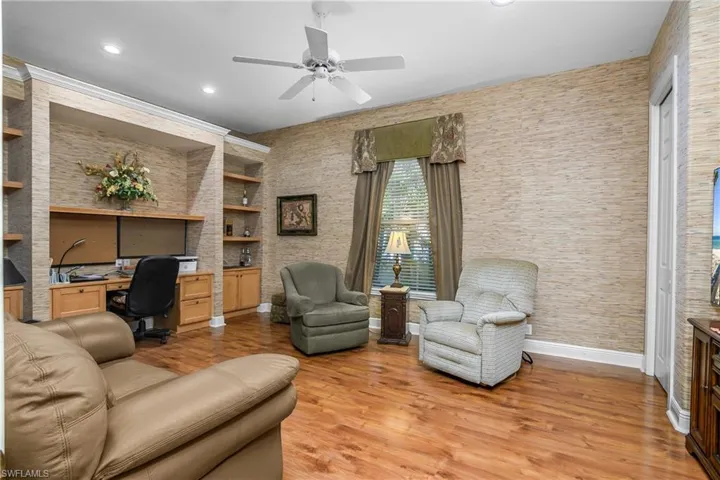 Den with built in desk and cabinets, wood flooring