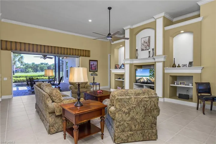 Large great room architecture with entertainment center and open sliders to lanai that "pocket" for full view of lanai, pool and spa and fairway.