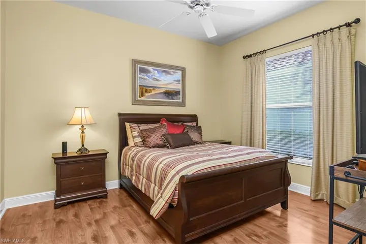 Guest bedroom with wood flooring
