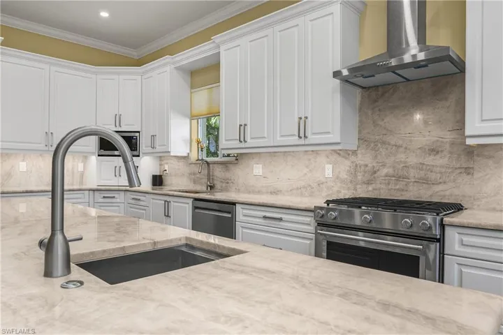 Second sink on island, natural gas range and ventilated hood, stainless steel appliances,.
