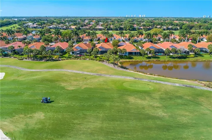Aerial view of house 'backyard' with golfer approaching a par 4 toward the green. Condos on horizon are at the Gulf of America beaches, approximately 20 minutes away.