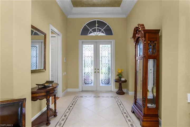 Foyer showcased by custom leaded glass double front door, neutral color ceramic tile flooring and tray ceiling. Front door also has a retractable "phantom screen" for cross ventilation on nice days. Door to left leads to 2 guest bedrooms and a full bath.