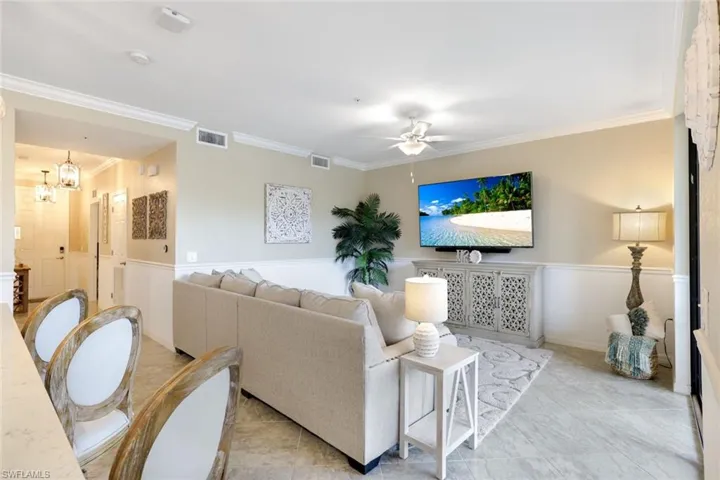 Living room featuring ornamental molding, and a ceiling fan