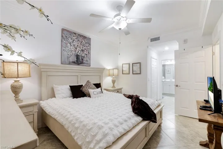 Bedroom featuring crown molding, connected bathroom, and a ceiling fan