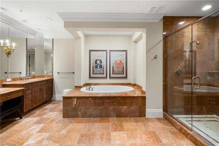 The primary retreat features a rare dual-bath configuration. One bath includes a soaking tub, walk-in shower, dual vanities, and a private water closet,