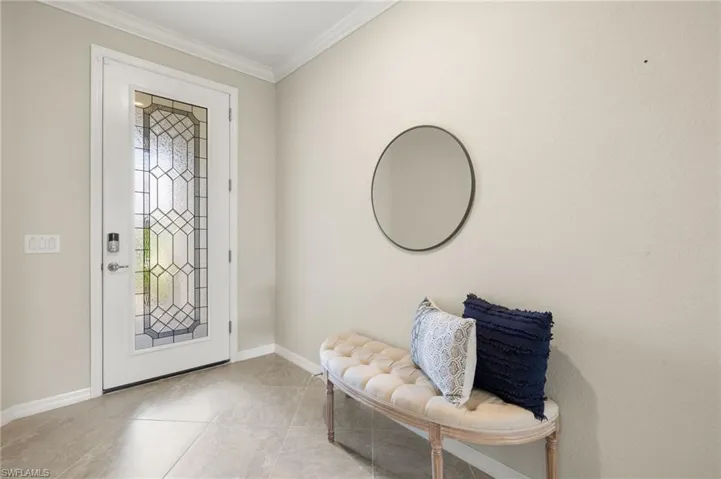 Foyer with crown molding and light tile flooring