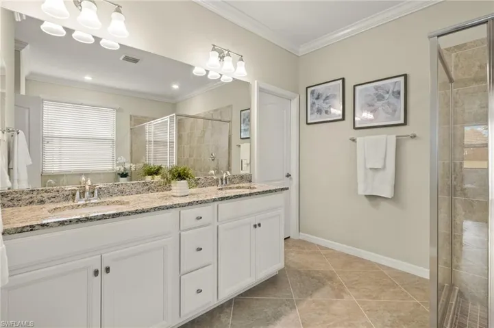 Bathroom, double vanity, tile flooring, and crown molding