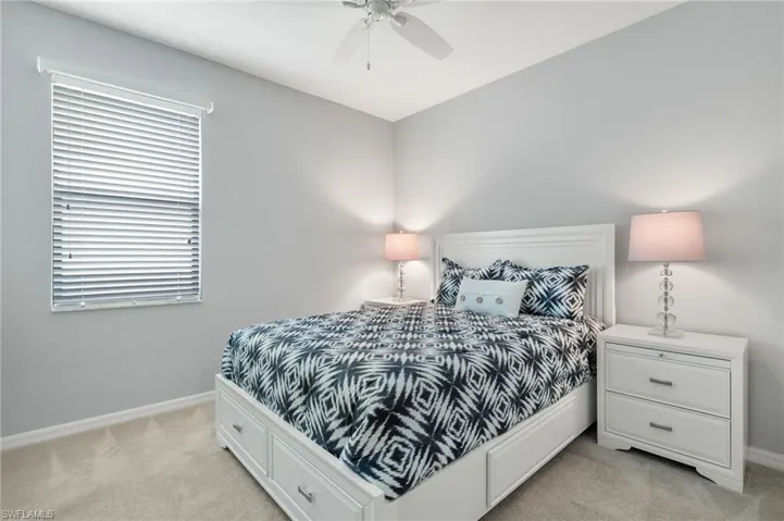 Bedroom with ceiling fan and light carpet