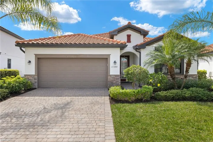 Mediterranean / spanish-style home featuring a front lawn and a garage