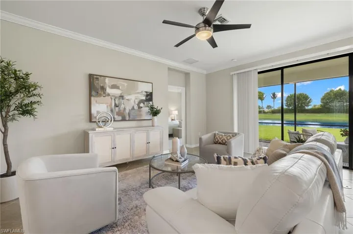 Tiled living room with crown molding, ceiling fan, and a water view
