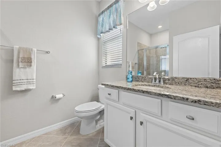 Bathroom with tile floors, vanity, and toilet