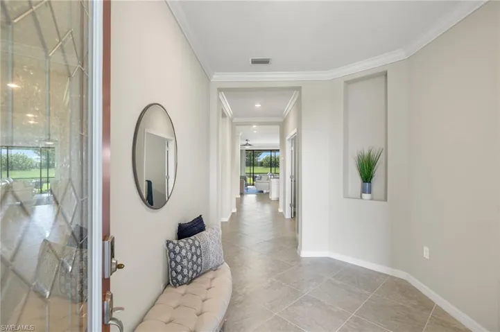 Corridor with tile floors and ornamental molding