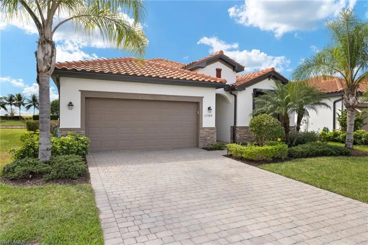 Mediterranean / spanish-style house featuring a garage and a front lawn