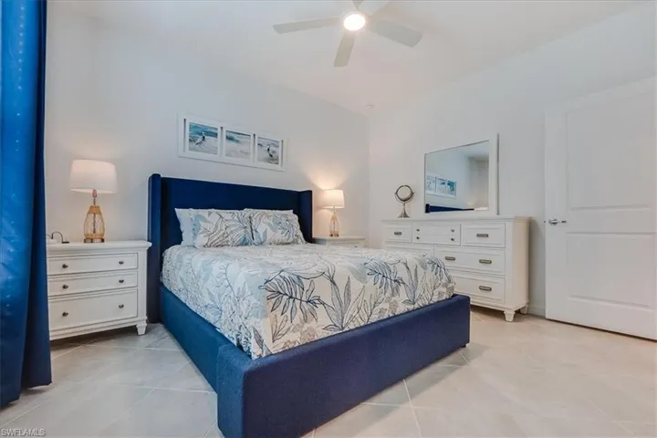 Bedroom with light tile patterned floors and ceiling fan