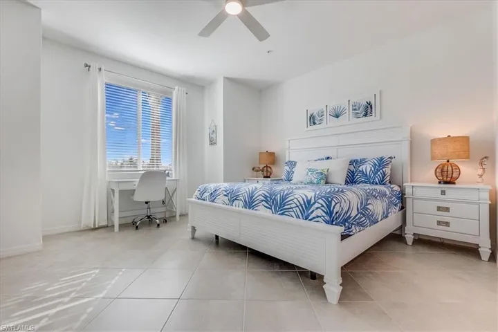 Tiled bedroom featuring ceiling fan