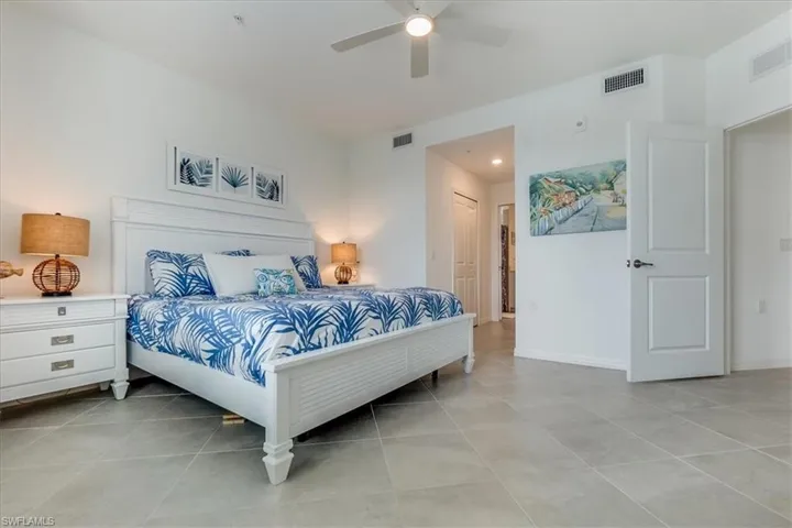 Bedroom with a closet, ceiling fan, and light tile patterned flooring