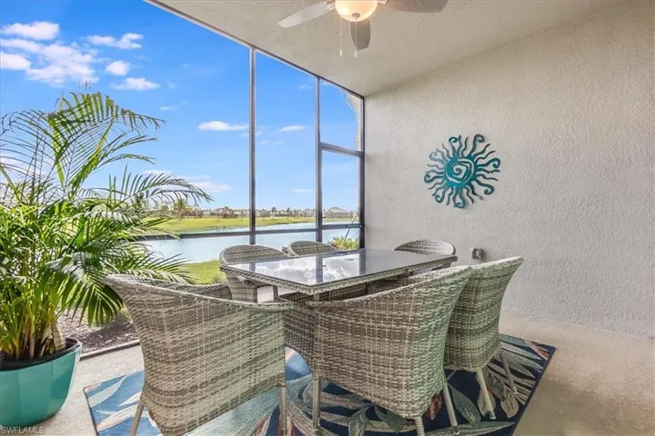 Sunroom / solarium featuring ceiling fan and a water view