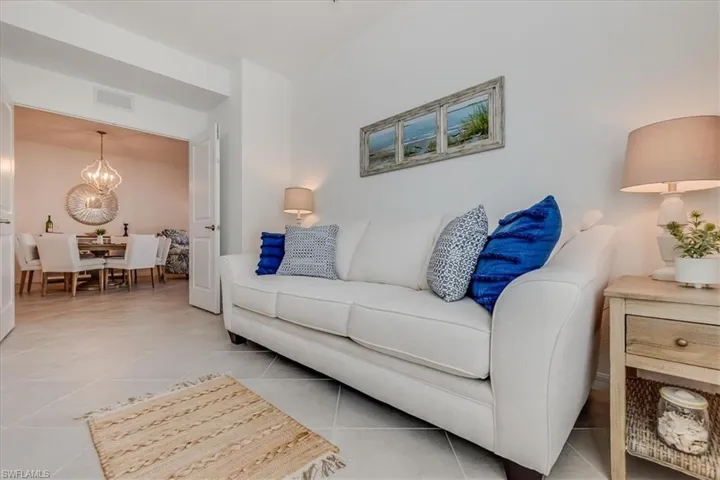 Tiled living room featuring a notable chandelier