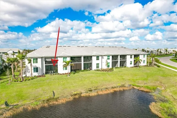 Back of house with a yard and a water view