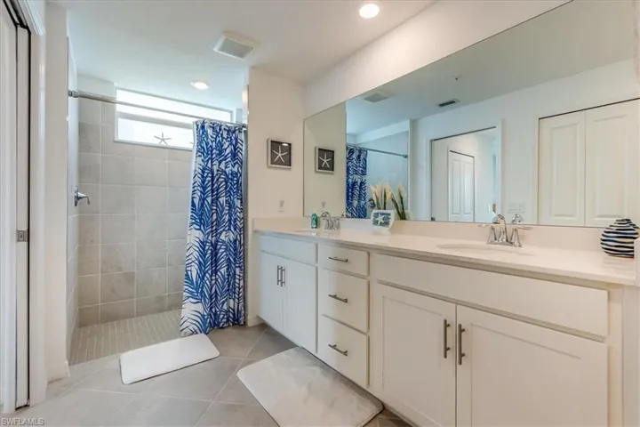 Bathroom with tile patterned floors, vanity, and a shower with shower curtain
