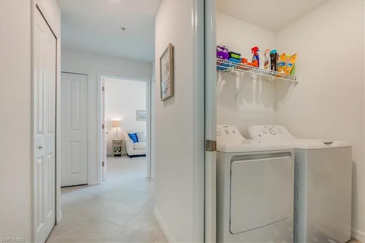 Laundry room with washer and dryer and light tile patterned floors