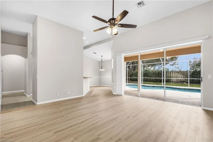 Unfurnished living room with a ceiling fan, lofted ceiling, light wood-style flooring, arched walkways, and recessed lighting