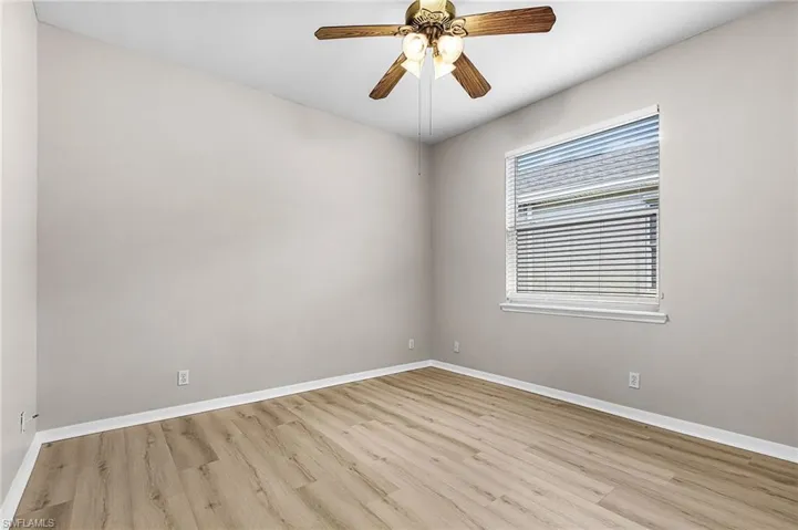 Empty room featuring ceiling fan and light wood finished floors