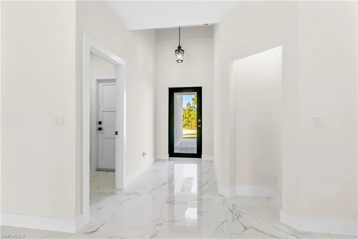 Entryway with a towering ceiling and light marble finish flooring