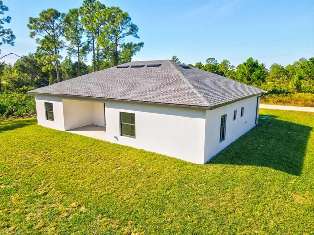 Rear view of house featuring a yard, stucco siding, and a patio area