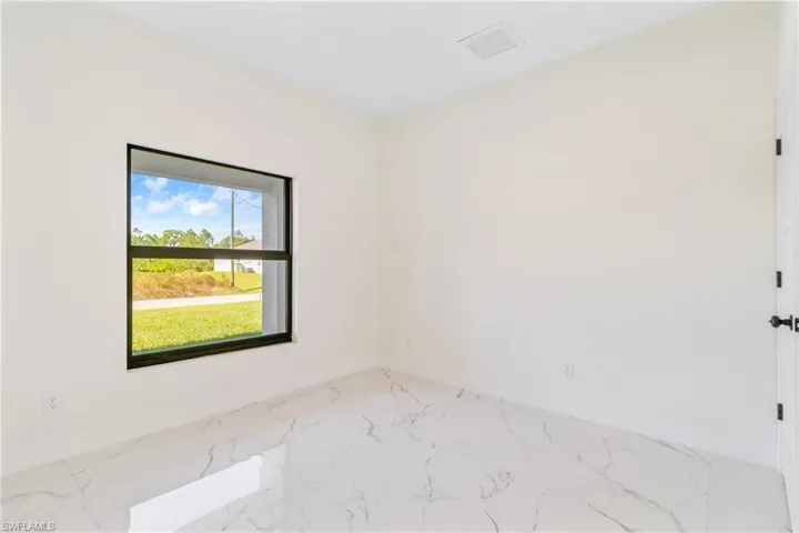 Empty room featuring marble finish flooring and baseboards