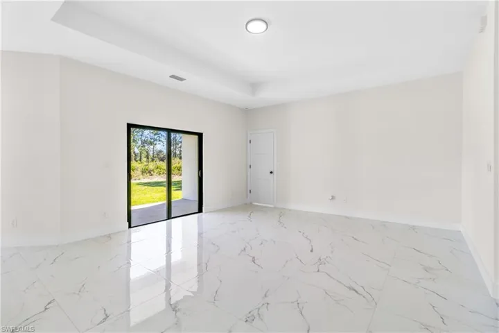 Empty room with light marble finish flooring and a raised ceiling