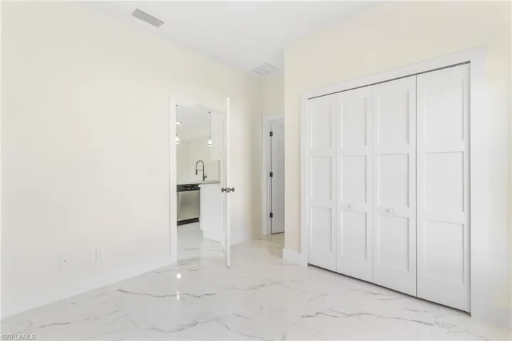 Unfurnished bedroom with light marble finish flooring and a closet