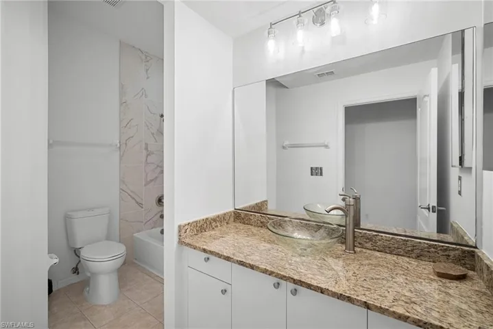 Bathroom featuring vanity, tub / shower combination, and light tile patterned floors