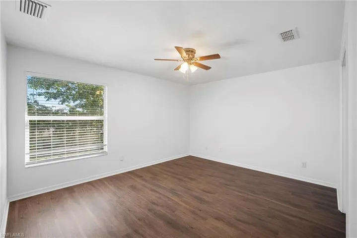 Spare room with a ceiling fan and dark wood-type flooring
