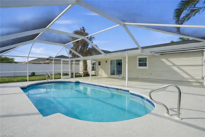 View of swimming pool featuring a patio area, a sunroom, and glass enclosure